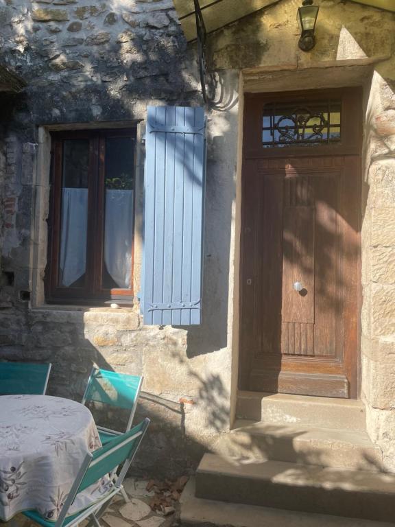 a house with a wooden door and a table and chairs at L'appart du Mas in Lamotte-du-Rhône