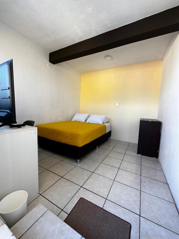a bedroom with a bed and a tv in it at CASA MARIN MANDIMBO in Oaxaca City
