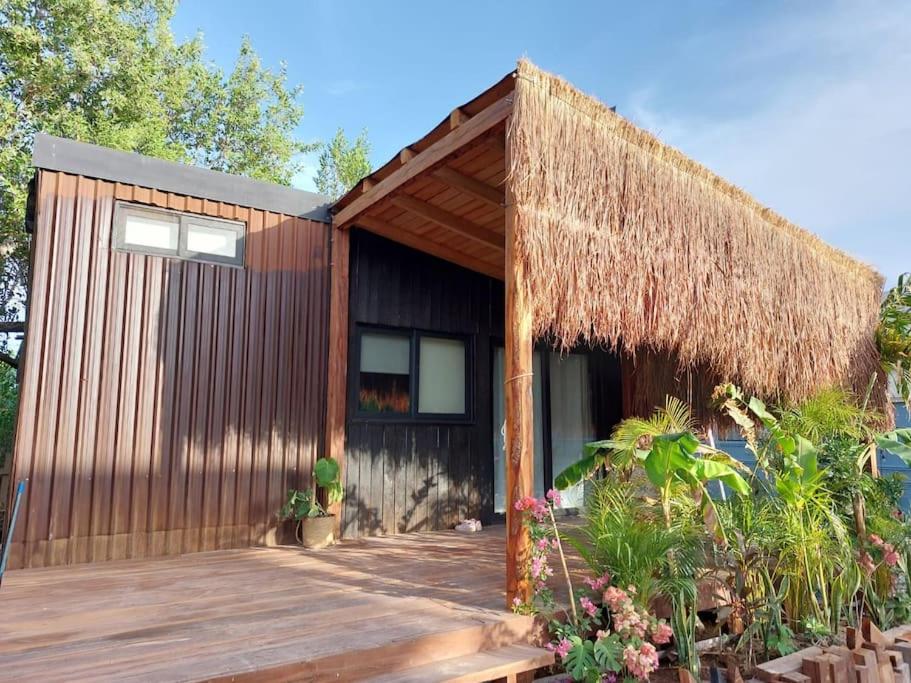 斯島的住宿－Polita Tiny House, con piscina, a 200m de la playa，一座带木甲板和稻草屋顶的小房子