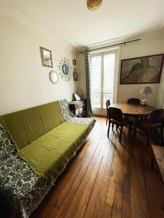 - une chambre avec un lit vert et une table dans l'établissement Flat in Montmartre/Abbesses, à Paris