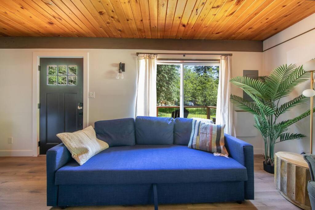 een blauwe bank in een woonkamer met een houten plafond bij R & R Chalet at Mt. Rainier in Ashford