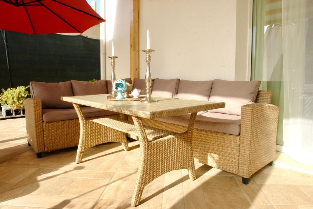 une table et une chaise avec un canapé et un parasol dans l'établissement Una Vita In Vacanza, à Comiso