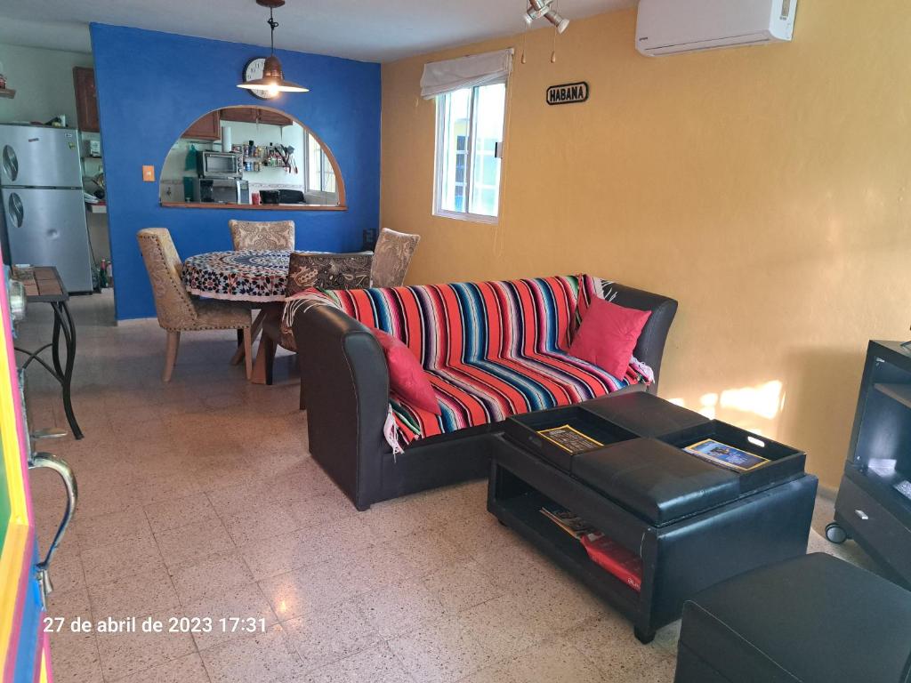 un soggiorno con divano e tavolo di Confortable y colorida casa con piscina a Cancún