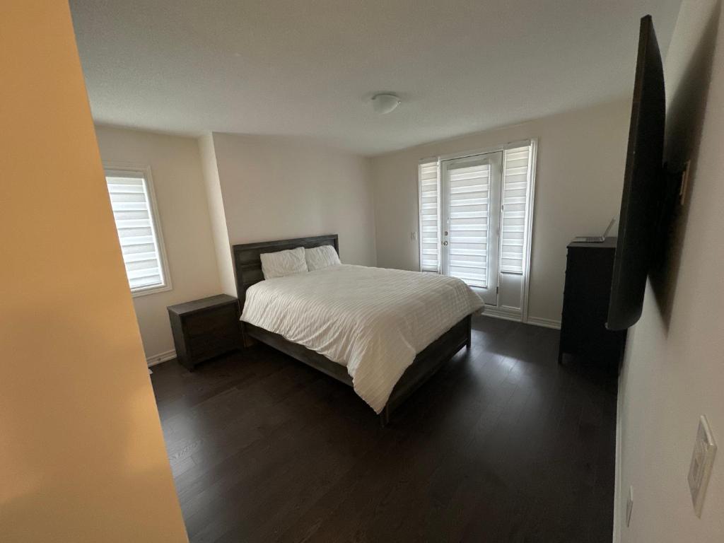 a bedroom with a bed and two windows at ON Residence in Hamilton