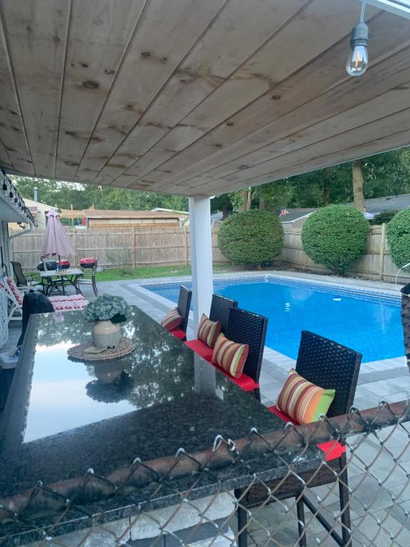 un patio con mesa y sillas junto a una piscina en Private Cozy Room, en Brockton