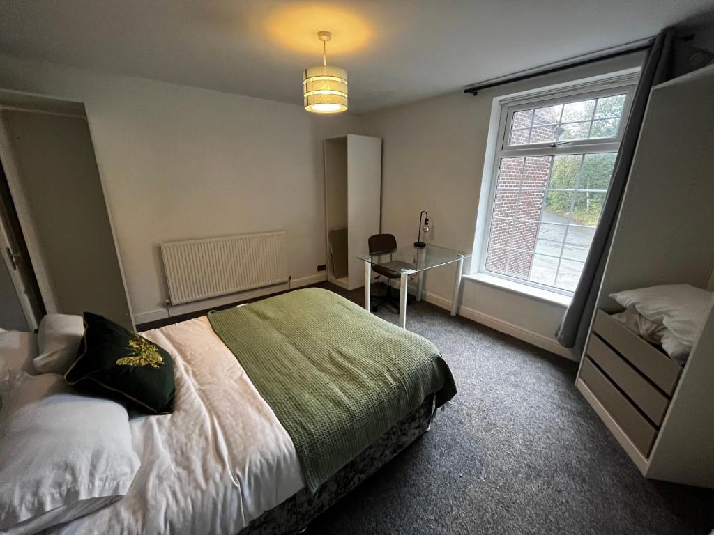 a bedroom with a bed and a desk and a window at Tranquil 3 Bed Oasis with Parking in Worsley