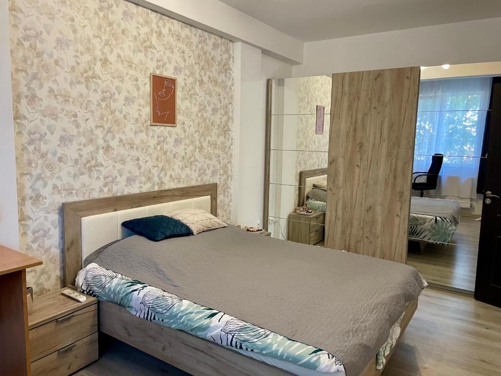 1 dormitorio con cama y espejo en la pared en Dream Sury Apartment - metrou Leonida, spital Obregia, en Bucarest