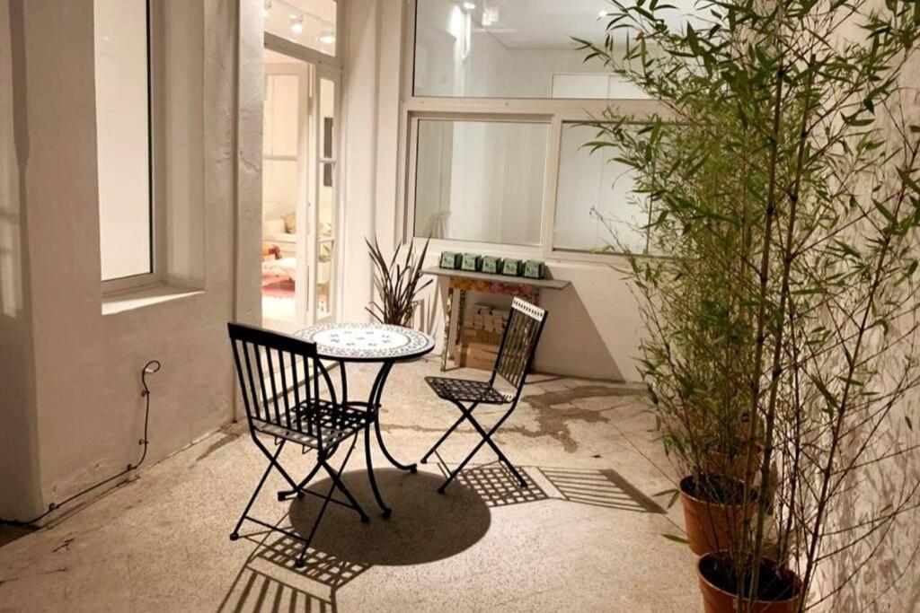 a table and two chairs in a room with plants at Palermo Apartment in Buenos Aires