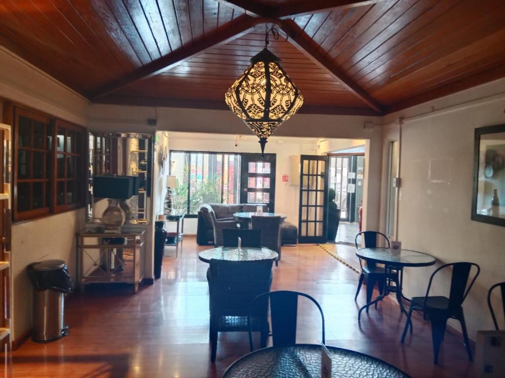 a living room with tables and chairs and a chandelier at Hotel Terrasol Iquique in Iquique