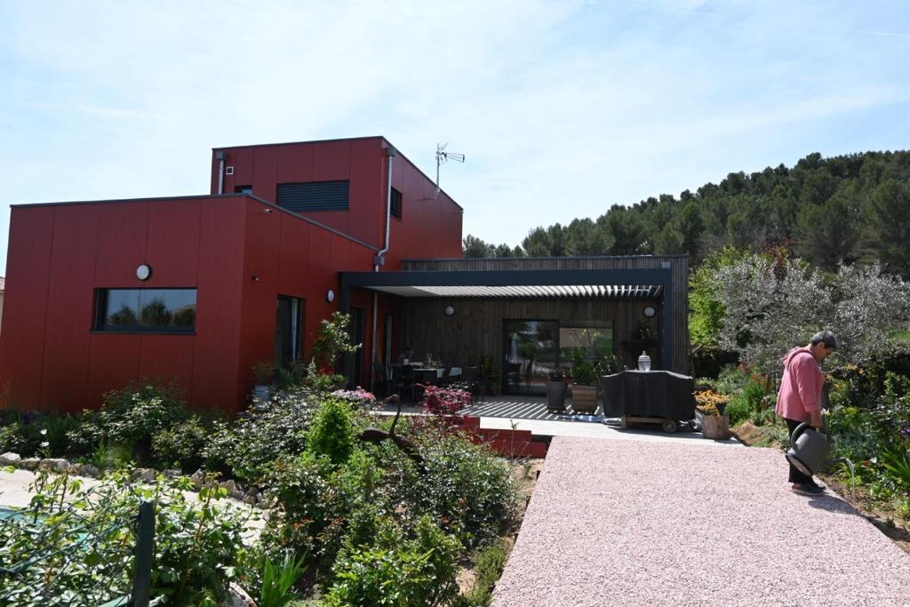 a man standing in front of a red house at nature in Gardanne