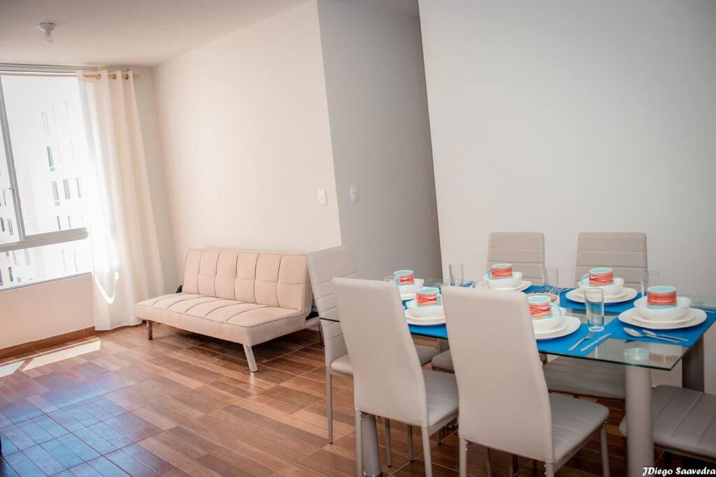 Vive Piura a tu manera في بيورا: غرفة طعام مع طاولة وكراسي بيضاء