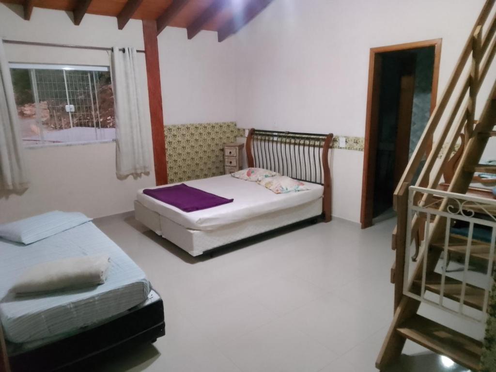 - une chambre avec 2 lits et un escalier dans l'établissement Recanto das pedras, à São Thomé das Letras