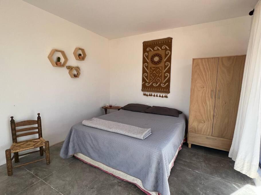 Casa en las montañas de San Miguel de Allende في سان ميغيل دي الليندي: غرفة نوم بسرير وكرسي