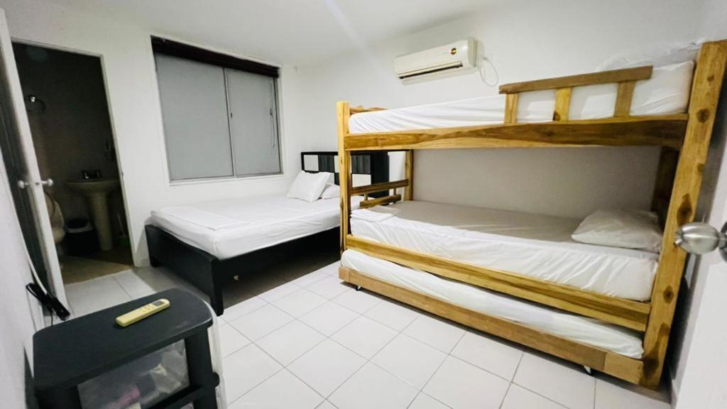 a room with two bunk beds and a chair at Apartamento Santa marta el rodadero in Gaira