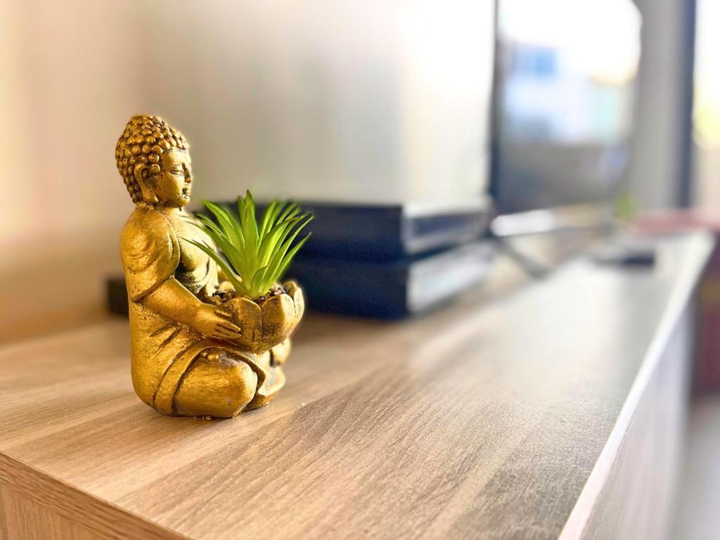 a small gold statue sitting on a table with a plant at *Le Royal*Havre De Paix*Wifi* in Marseille