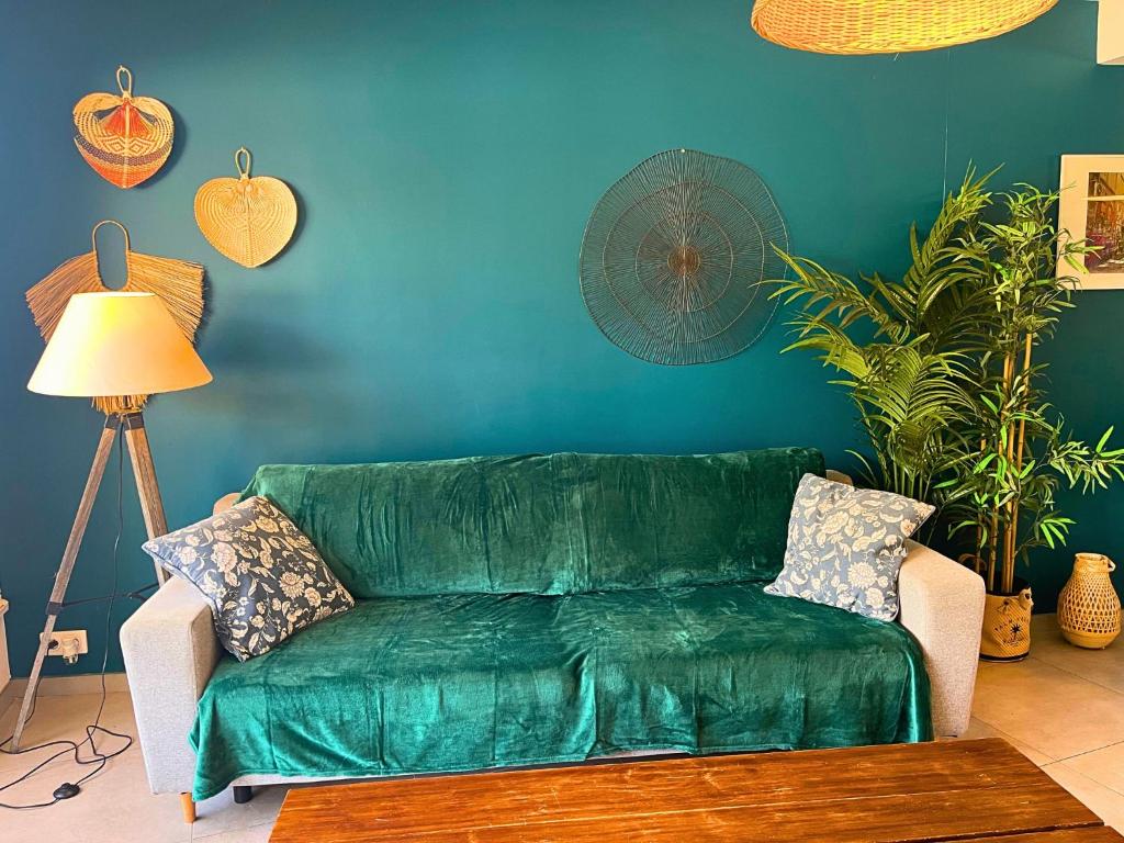 a green couch in a living room with a blue wall at *Le Royal*Havre De Paix*Wifi* in Marseille