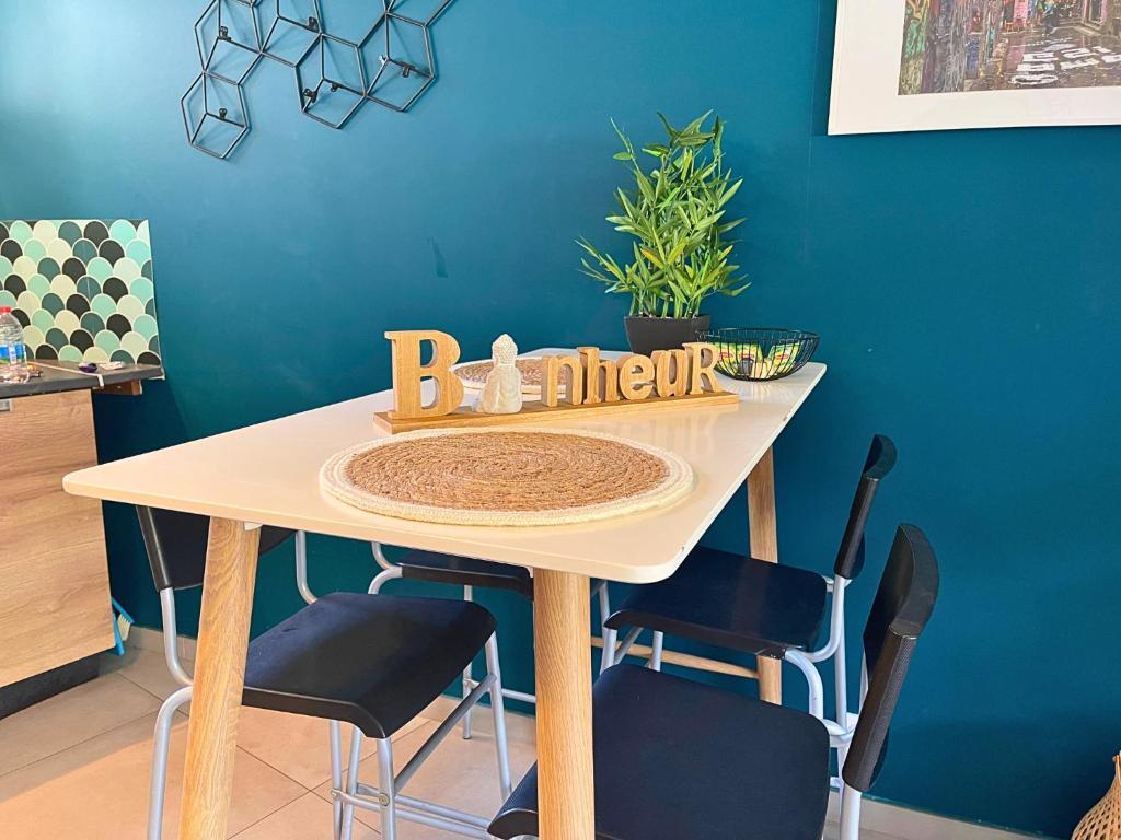 a dining room table with chairs and a blue wall at *Le Royal*Havre De Paix*Wifi* in Marseille