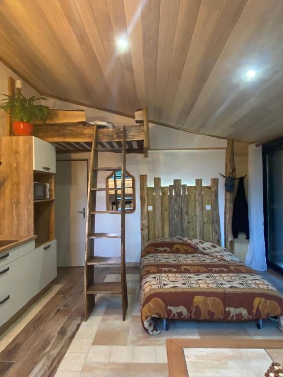 a bedroom with a bed and a wooden ceiling at Studio famille, lit aventurier in Saint-Laurent-de-Neste