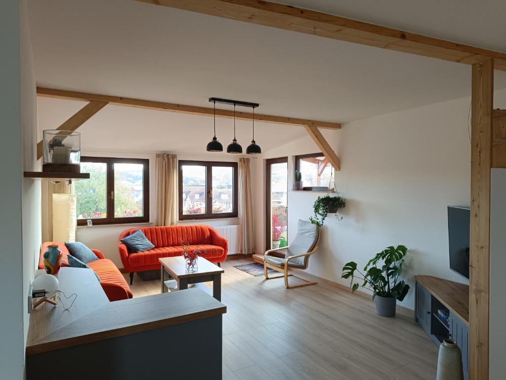 a living room with a red couch and a table at Ferienwohnung Fernblick in Saalfeld