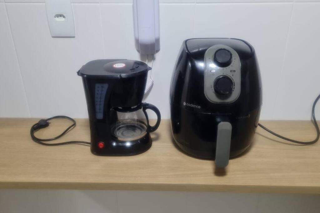 a coffee maker and a toaster sitting on a shelf at Cabo Frio - Temporadas in Cabo Frio