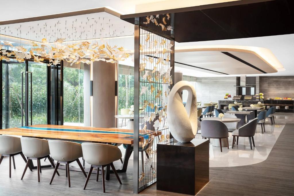上海市にある上海 マリオット ホテル ホンチャオの長いテーブルと椅子が備わるレストラン