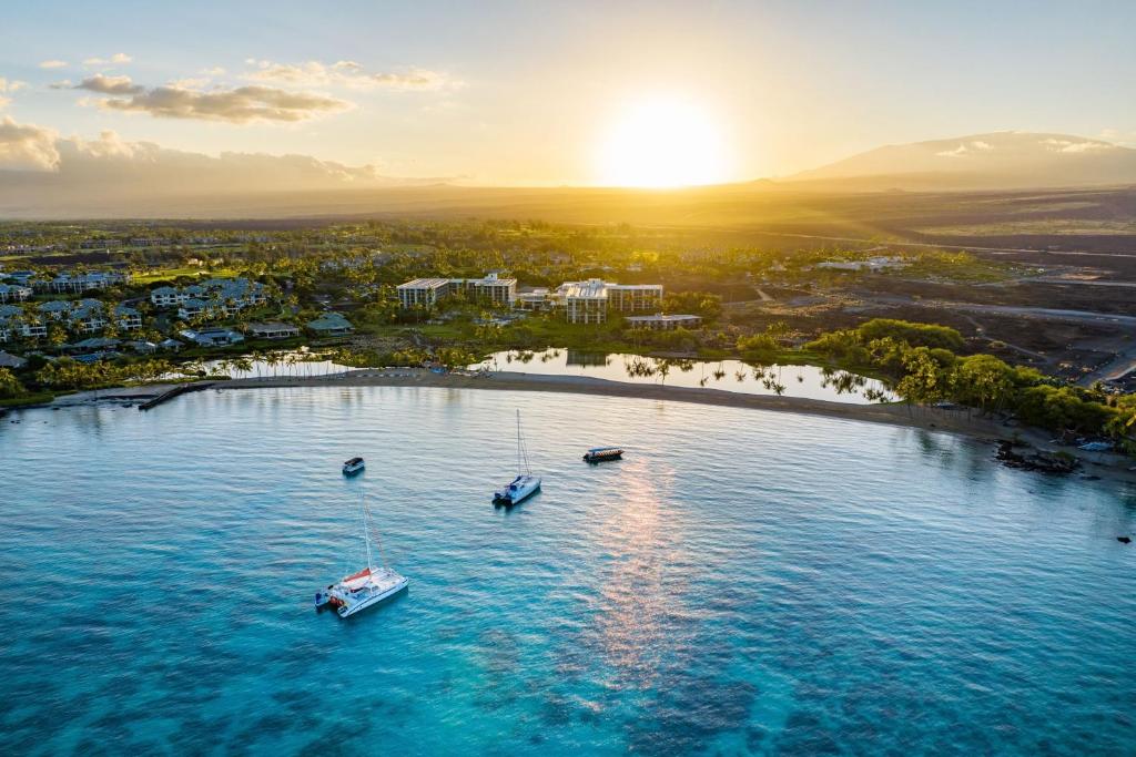 an island with boats in the water at sunset at Waikoloa Beach Marriott Resort & Spa in Waikoloa