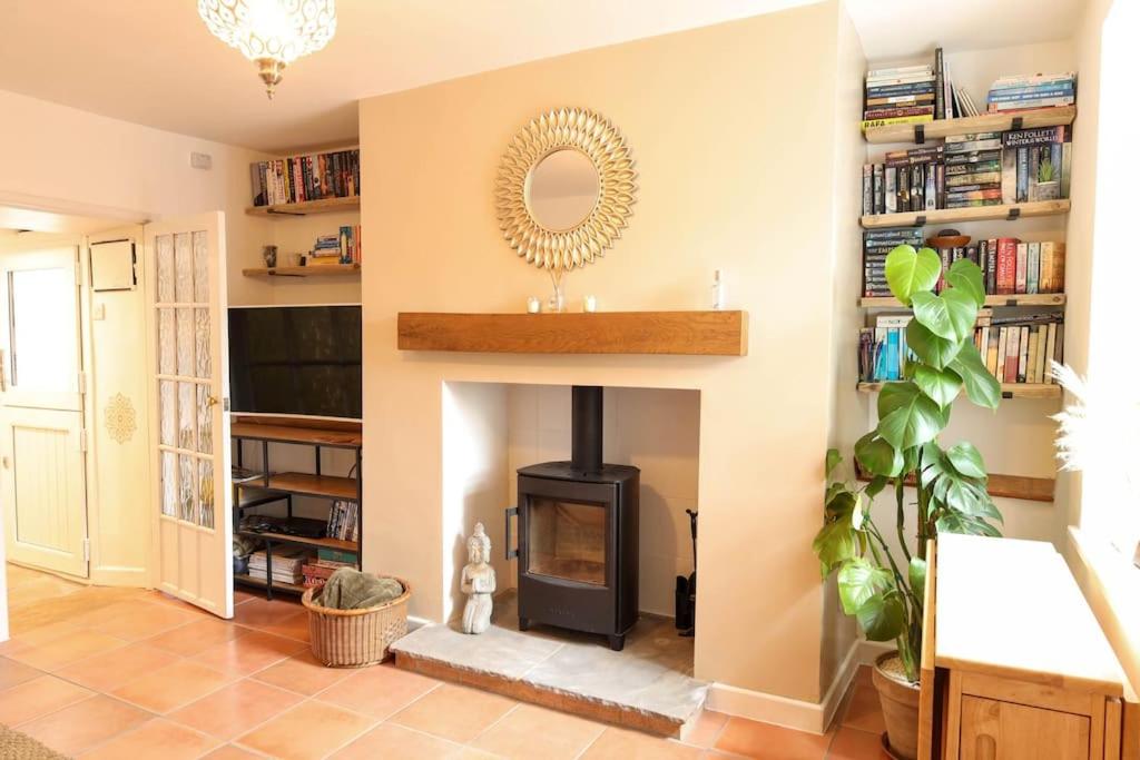 a living room with a fireplace and a mirror at May Cottage, Sofa Bed, Garden 