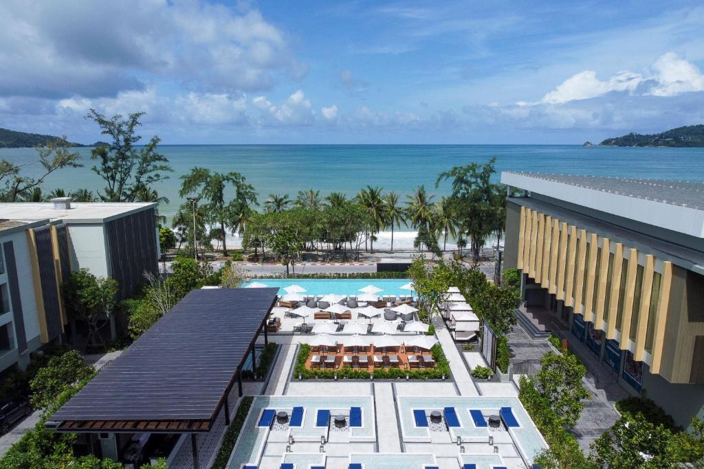 巴東海灘的住宿－Four Points by Sheraton Phuket Patong Beach Resort，享有带游泳池和海洋的度假村的空中景致