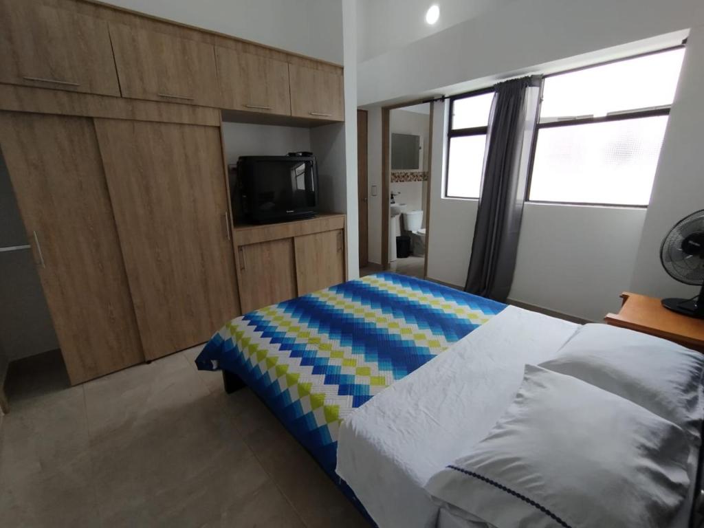 a bedroom with a bed and a tv in it at Habitación doble con baño privado in Sabaneta