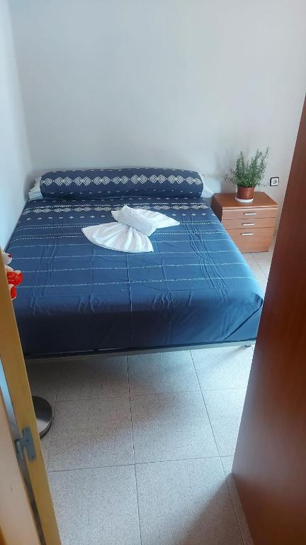 Casa particular Tatiana في بادالونا: سرير بملاءات ومخدات زرقاء في الغرفة