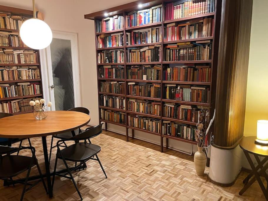 een kamer met een tafel en stoelen en boekenplanken met boeken bij Quaint, cozy apart in best location in Montevideo