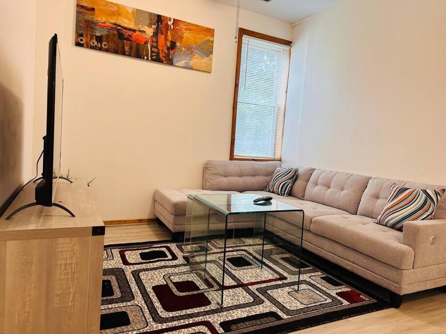 a living room with a couch and a glass table at Greater Grand Crossing/Hyde Park in Chicago