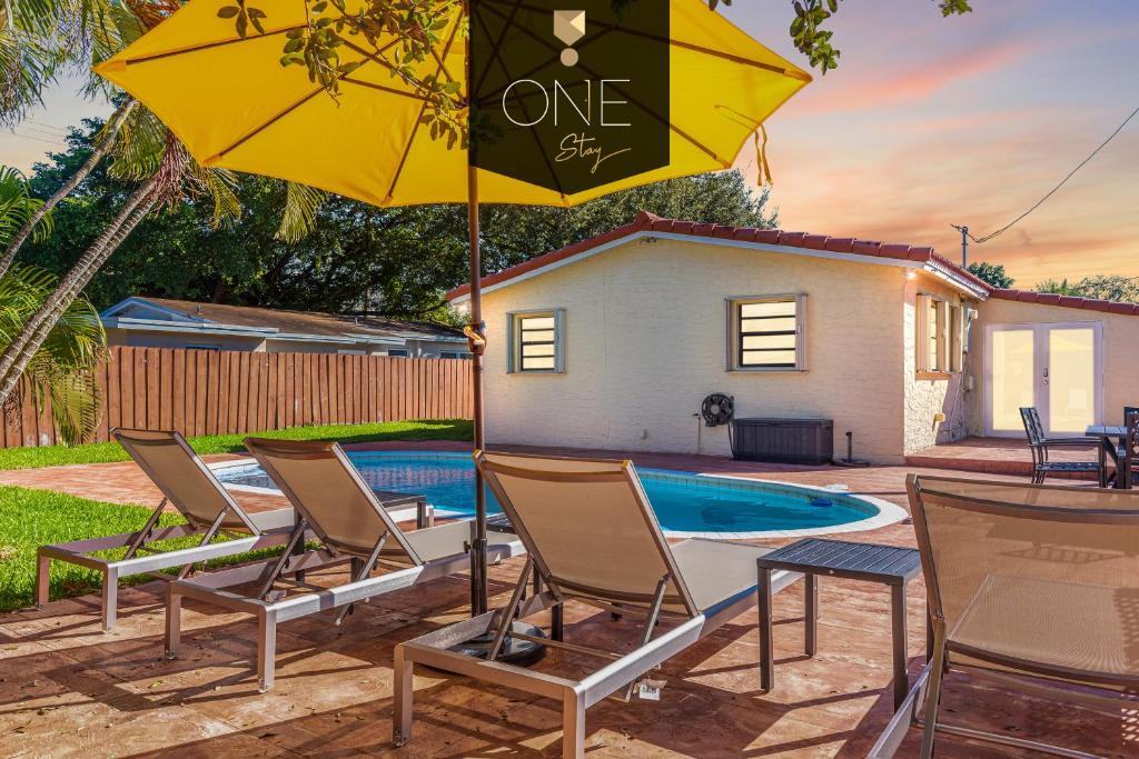 grupa krzeseł i parasol obok basenu w obiekcie 3Bed Glamour Iconic Hollywood Pool Home w mieście Hollywood