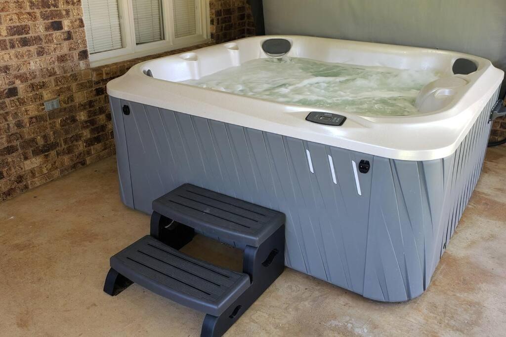eine Badewanne mit einem Stuhl davor in der Unterkunft Hot Tub, Privacy, sleeps 10 & TONS of Space! in Lubbock