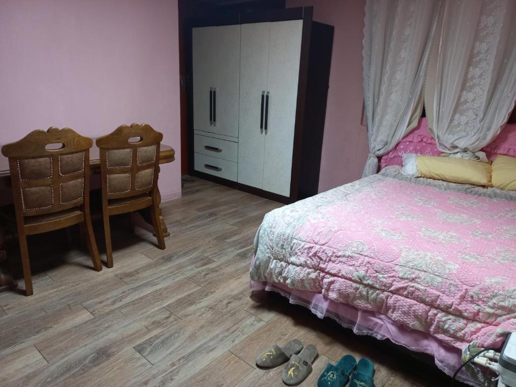 um quarto com uma cama e uma cómoda e alguns sapatos em Esther Queen House em Gwangju