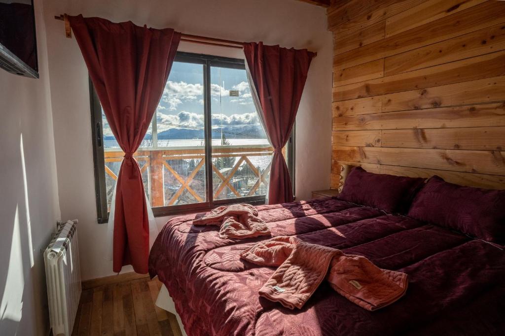 מיטה או מיטות בחדר ב-Dpto tipo cabaña con vista al lago