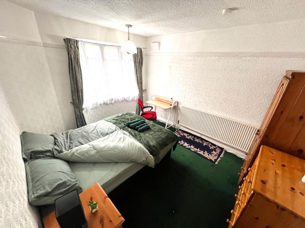 a small room with a bed and a window at Stonehouse Cottage Near QE & UOB in Birmingham