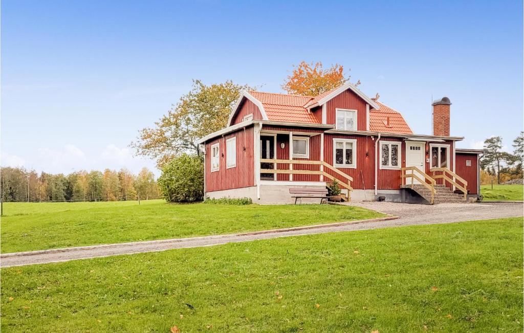 uma casa vermelha e branca com um campo de relva em Gorgeous Home In Eksj With Kitchen em Eksjö