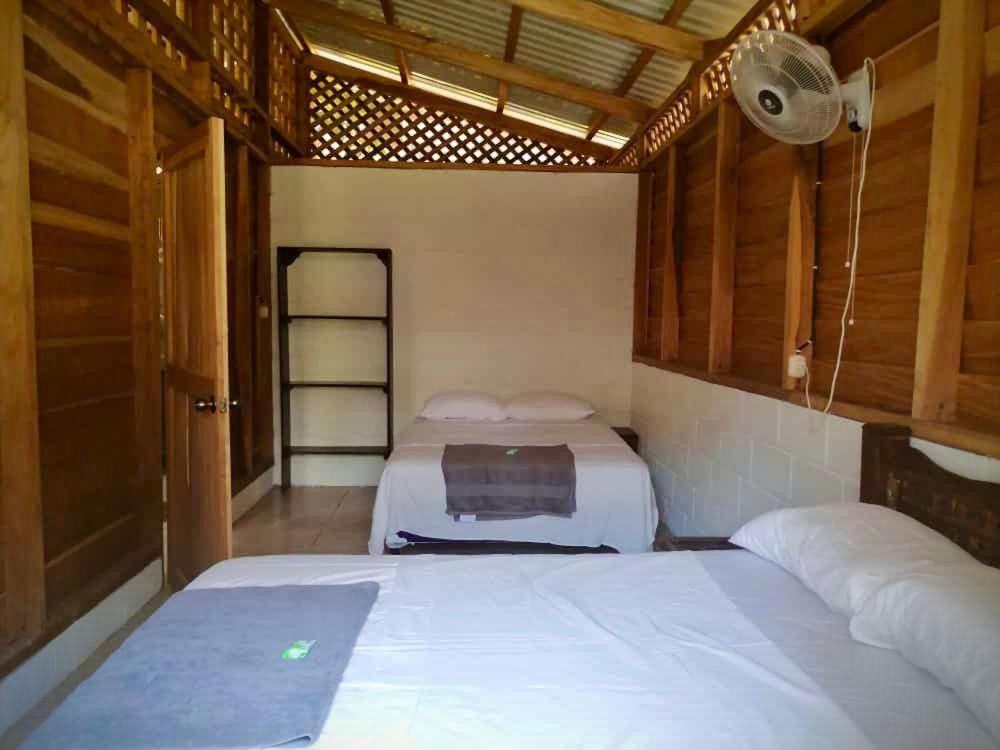 1 dormitorio con 2 camas y ventilador. en Rustika Logde en Puerto Viejo