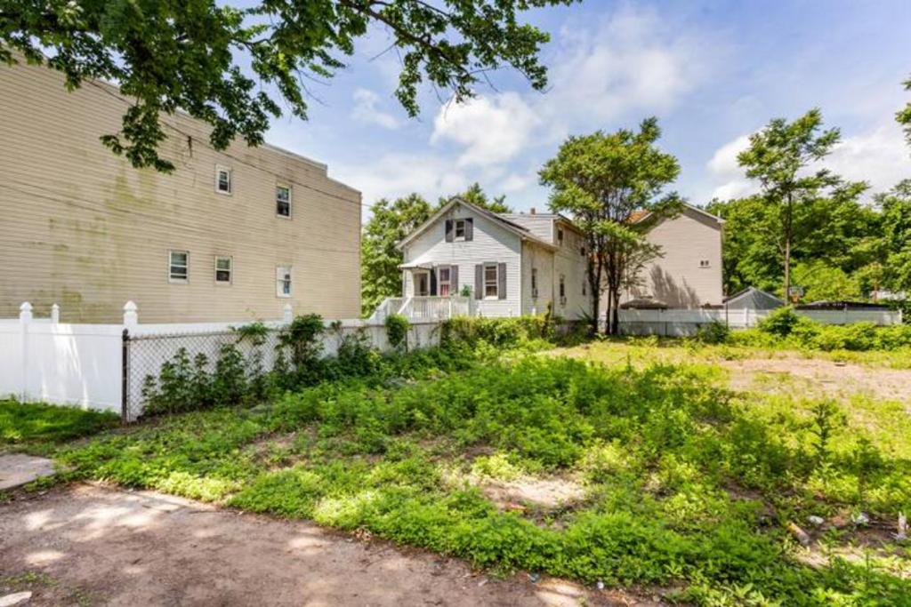 a white house with a white fence and a yard at cozzy room with private entrance and drive way in Arlington