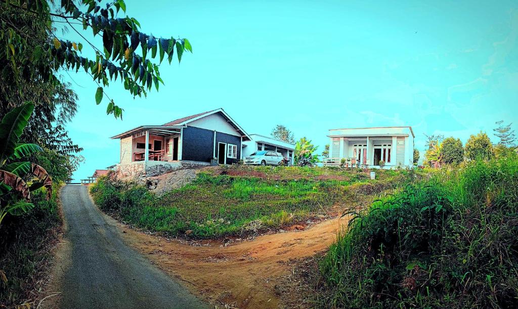 ein Haus auf einem Hügel neben einer unbefestigten Straße in der Unterkunft Mount Rinjani Guest House in Sajang
