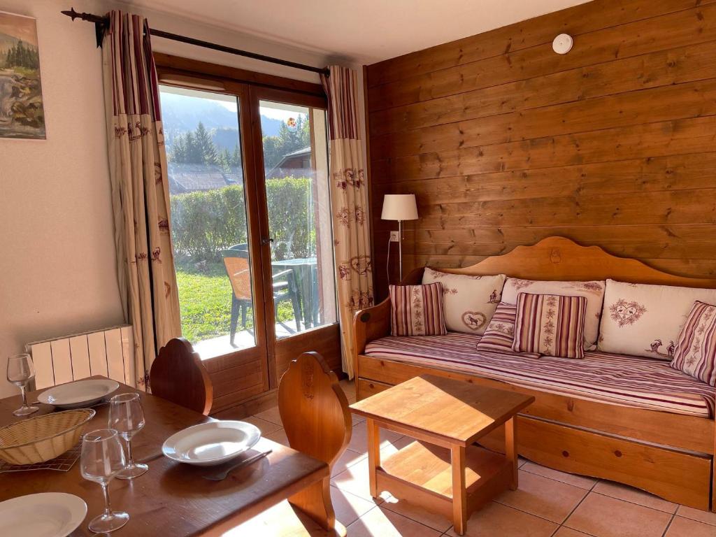 Cette chambre comprend un lit, une table et une table. dans l'établissement Appartement Calme avec Piscine, Terrasse et Skibus Proche Centre Samoëns - FR-1-624-144, à Samoëns