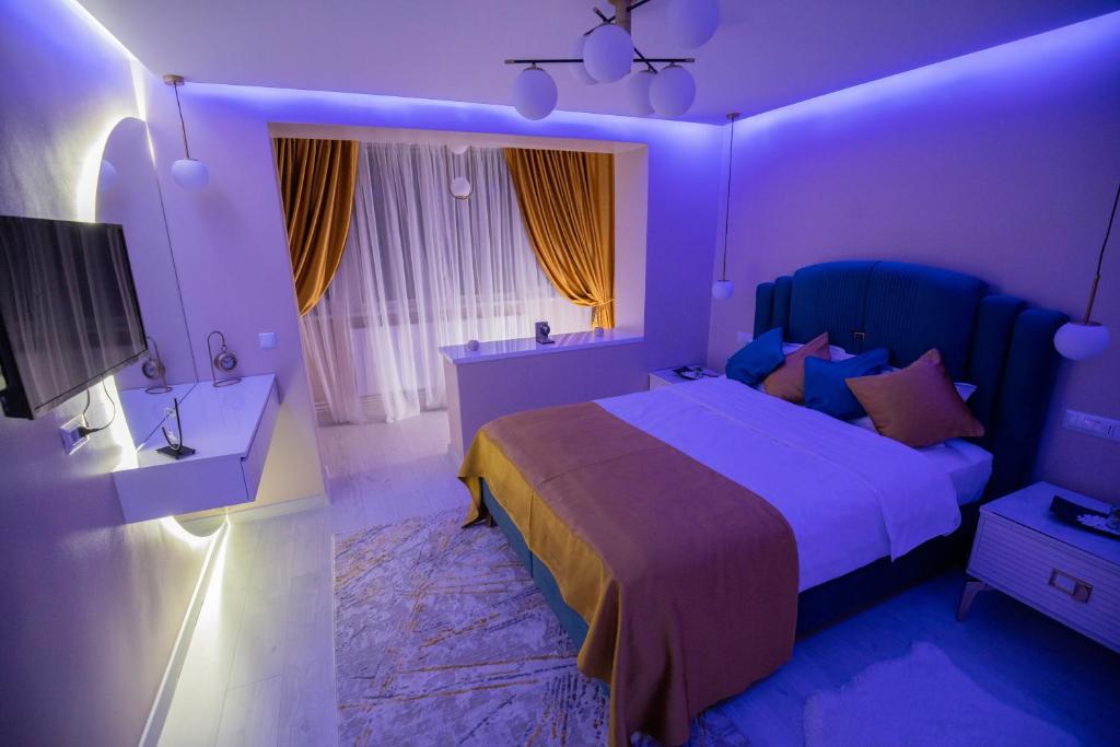 um quarto roxo com uma cama e uma televisão em Alpasio Rentals 2 em Galaţi