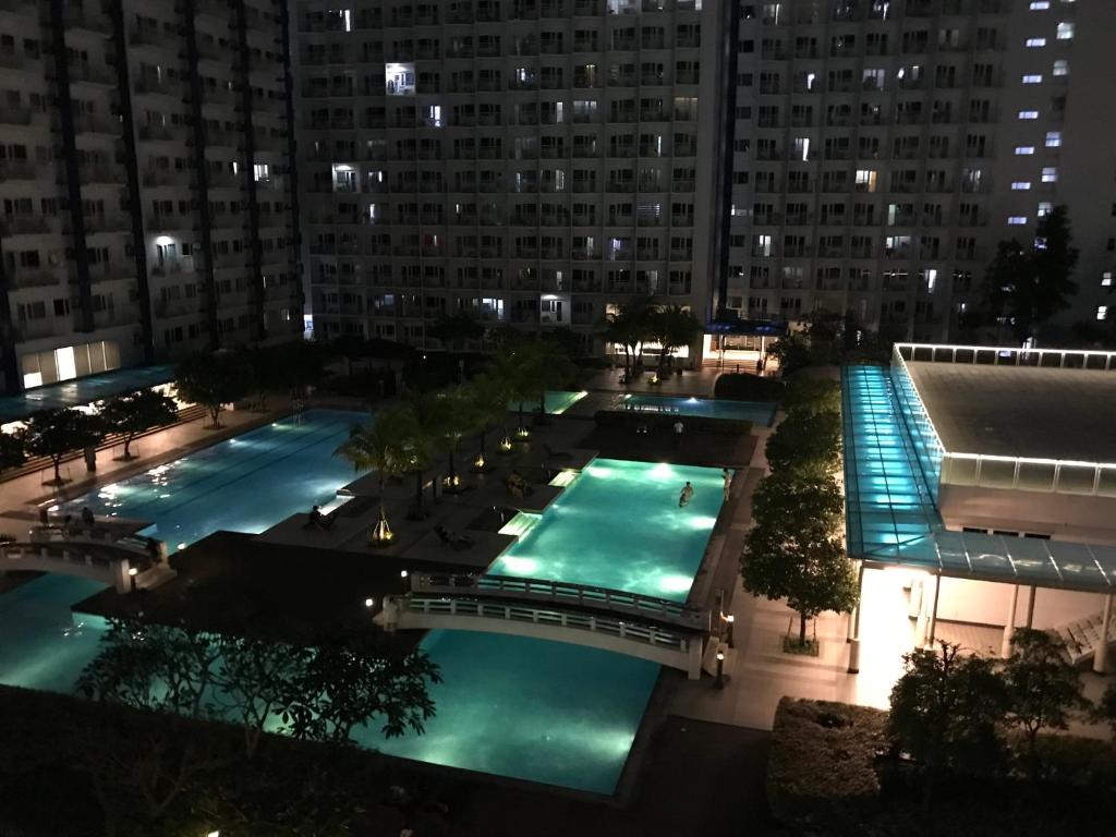 an overhead view of two pools in a city at night at Condo with Balcony at Makati SM Jazz in Manila