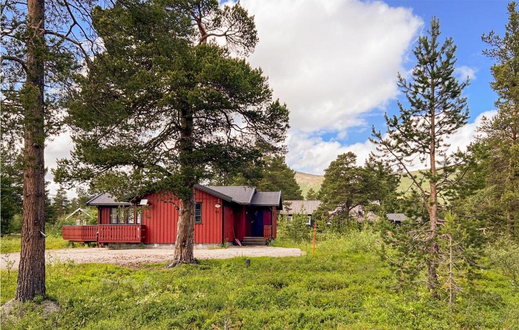a red cabin in the middle of a forest at 3 Bedroom Nice Home In Bjorli in Bjorli
