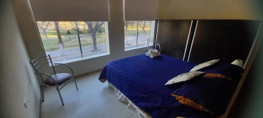 una camera con letto blu, cuscini e sedia di Confortable y Amplio loft a Mendoza