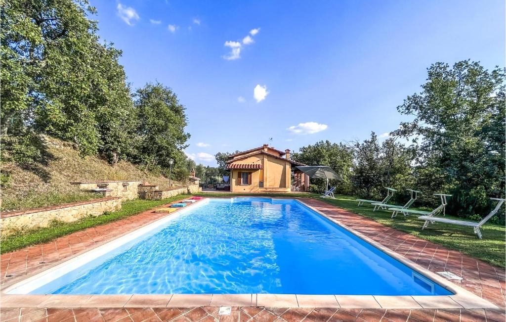 una piscina con una casa sullo sfondo di Gorgeous Home In Monte San Savino With Kitchen a Monte San Savino