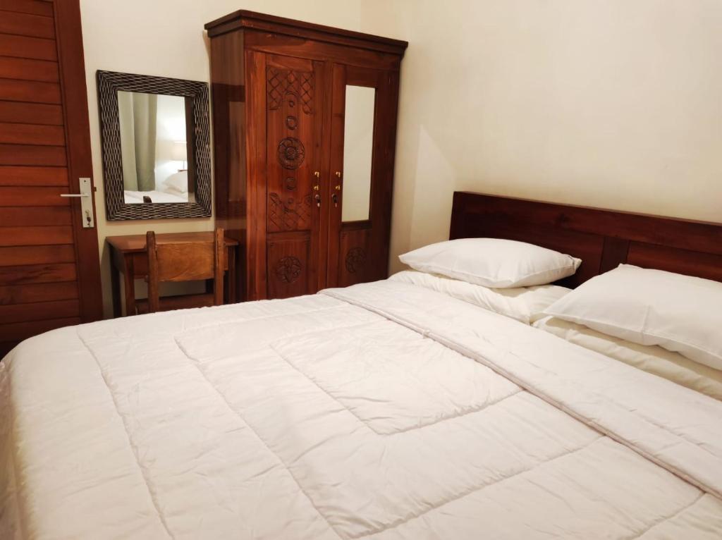 - une chambre avec un grand lit blanc et un miroir dans l'établissement Private house, à Ubud