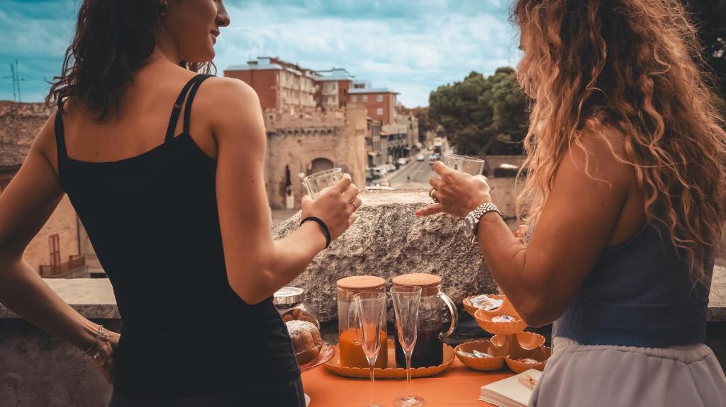 zwei Frauen stehen neben einem Tisch mit Brille in der Unterkunft arco augusto in Fano