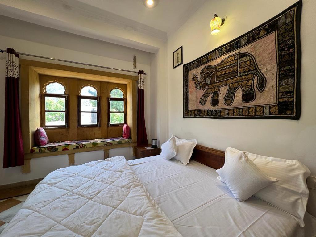 Postel nebo postele na pokoji v ubytování Hotel Pushkar Golden Haveli